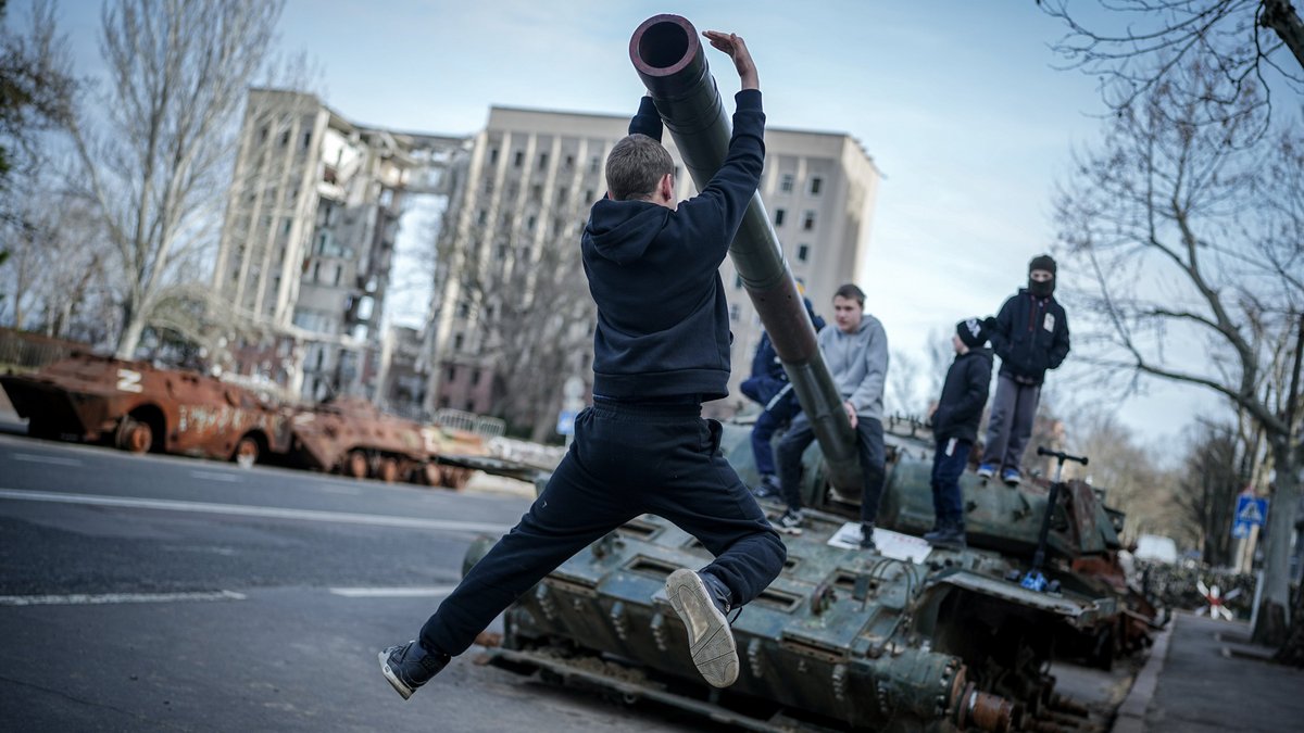 Alltag in der ukrainischen Hafenstadt Mykolajiw bei Odessa: Kinder spielen auf einem zerstörten russischen Panzer. Foto: Kay Nietfeld, dpa